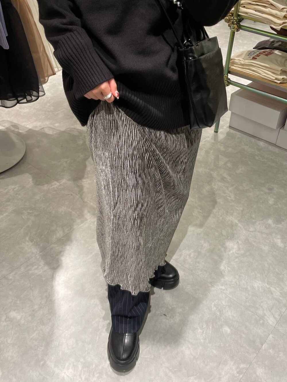 ブラック系のブーツ、ブルー系のその他パンツ、ブラック系のニット/セーターを着用したレディースの冬コーディネートの2枚目の写真