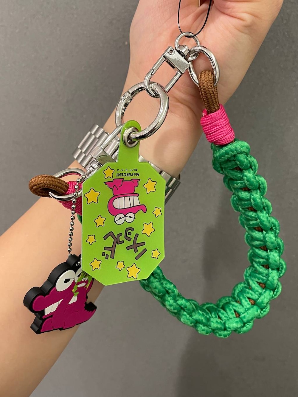 イエロー系のポーチ、ブルー系のキーホルダー、ホワイト系のキーホルダーを着用したレディースの夏コーディネートの3枚目の写真