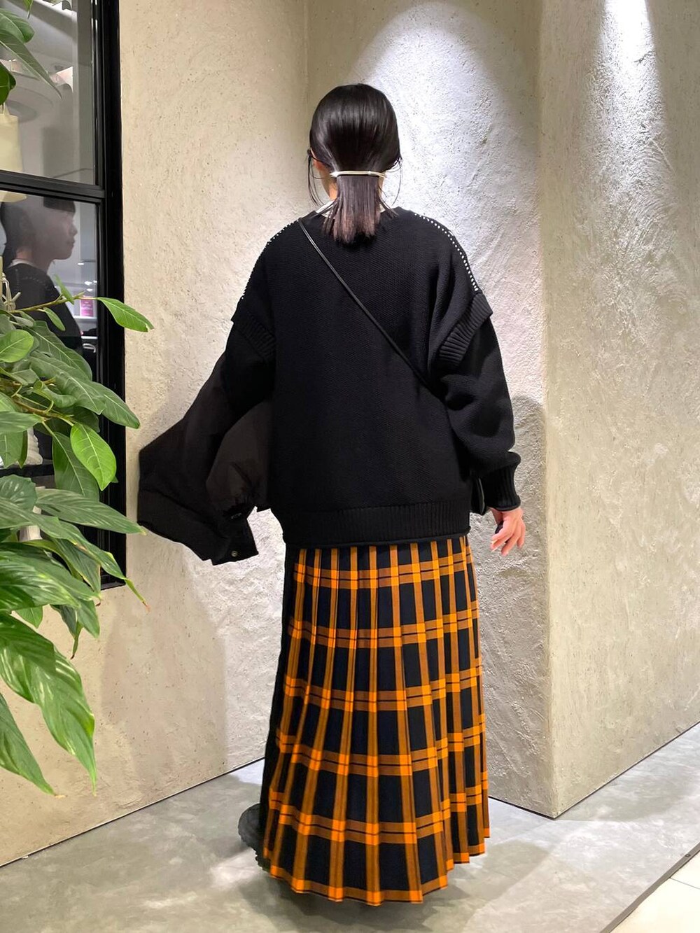 ブラック系のショルダーバッグ、ブラック系のダウンジャケット/コート、ブラック系のTシャツ/カットソーを着用したレディースの冬コーディネートの8枚目の写真