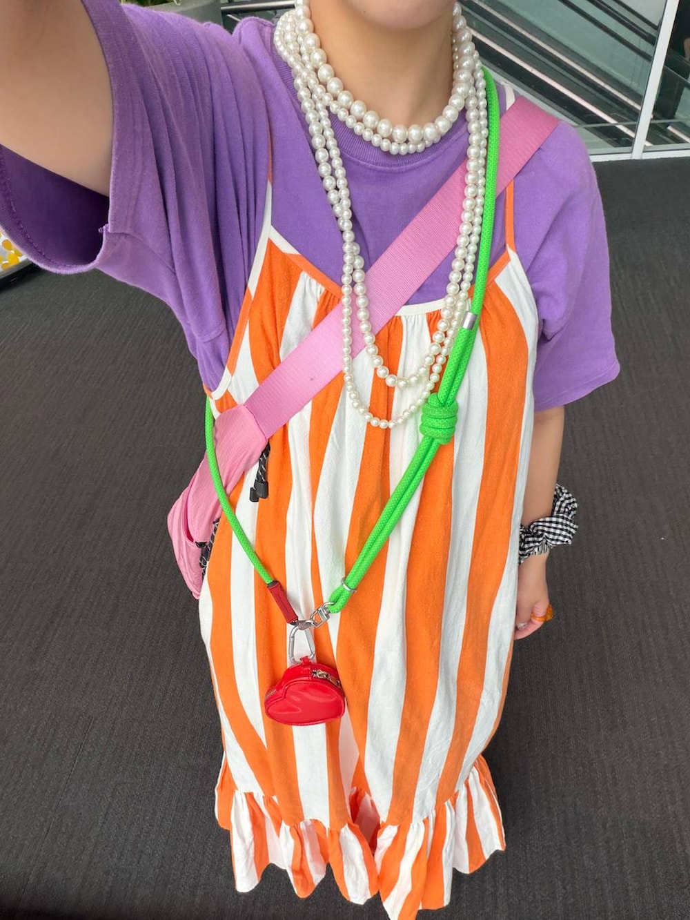 ピンク系のショルダーバッグ、ベージュ系のネックレス、ブラック系のシュシュを着用したレディースの夏コーディネートの7枚目の写真