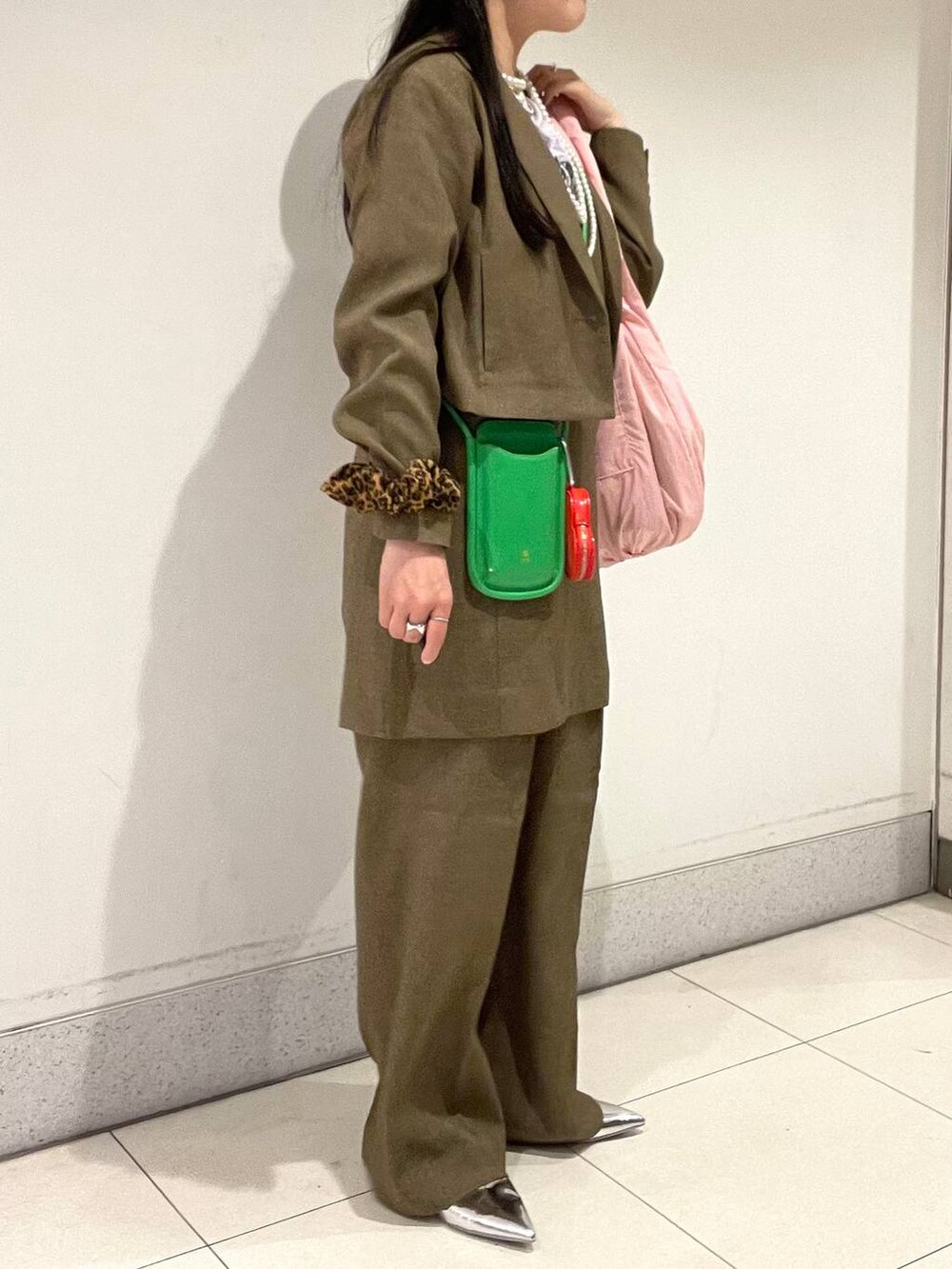 ブラウン系のスラックス、ブラウン系のテーラードジャケット、ブラウン系のキャミソールを着用したレディースの春コーディネートの5枚目の写真