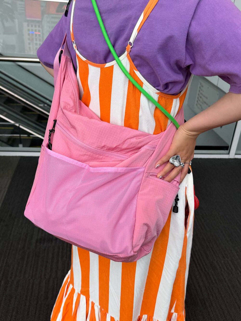 ピンク系のショルダーバッグ、ベージュ系のネックレス、ブラック系のシュシュを着用したレディースの夏コーディネートの8枚目の写真