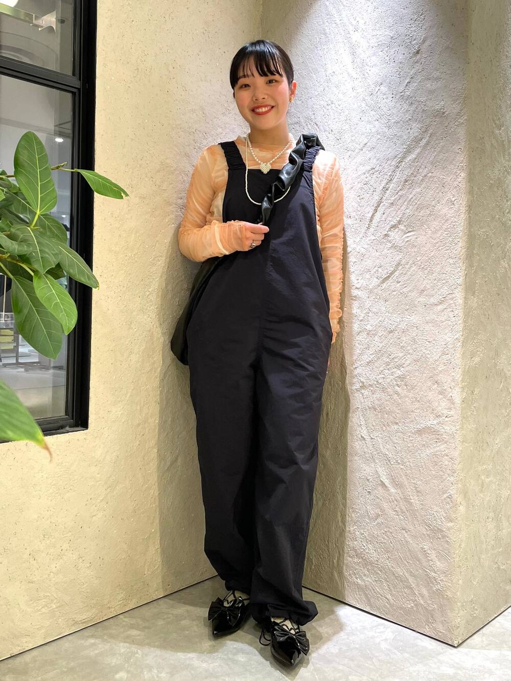 ブラック系のトートバッグ、ブラック系のパンプス、ピンク系のシャツ/ブラウスを着用したレディースの春コーディネートの3枚目の写真