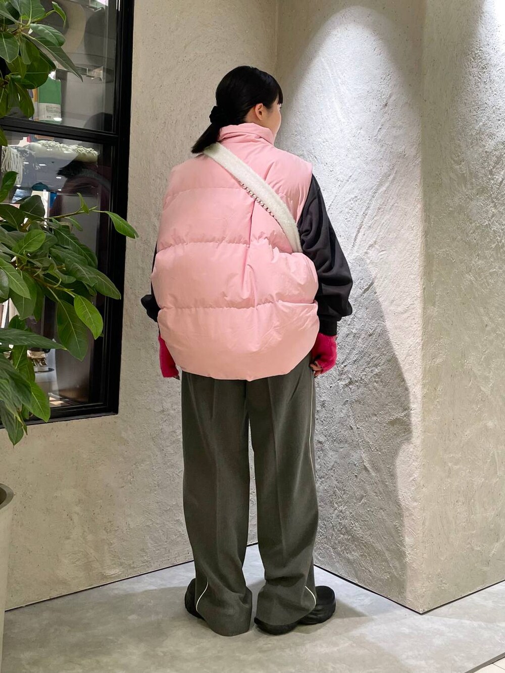 ピンク系のダウンベスト、グレー系のその他パンツ、ブラック系のスウェットを着用したレディースの秋コーディネートの4枚目の写真
