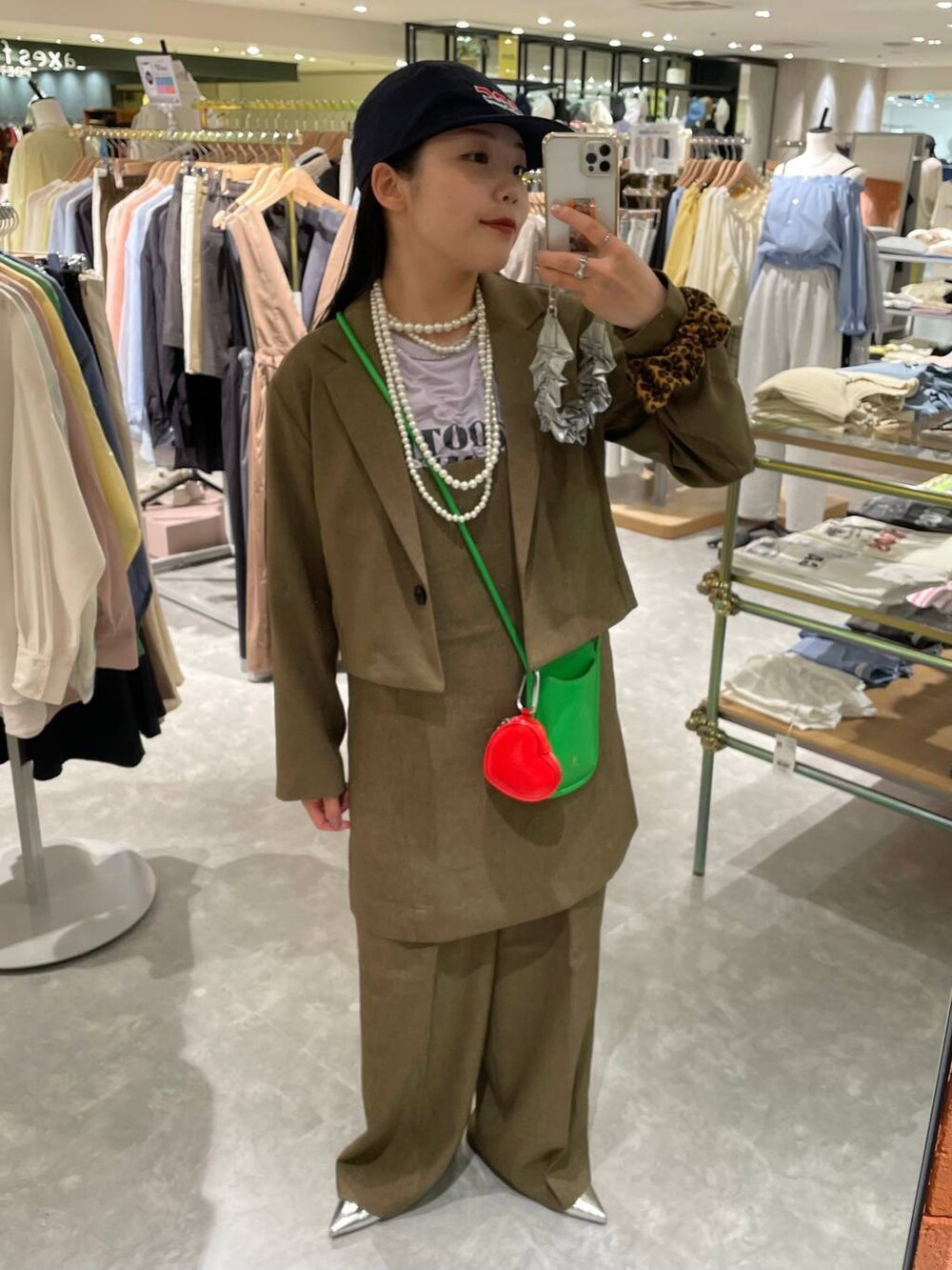 ブラウン系のスラックス、ブラウン系のテーラードジャケット、ブラウン系のキャミソールを着用したレディースの春コーディネートの9枚目の写真