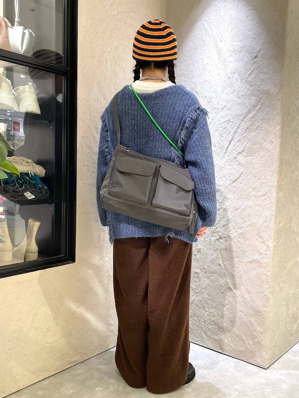 ホワイト系のTシャツ/カットソー、ブルー系のニット/セーター、ブラック系のブーツを着用したレディースの冬コーディネートの3枚目の写真