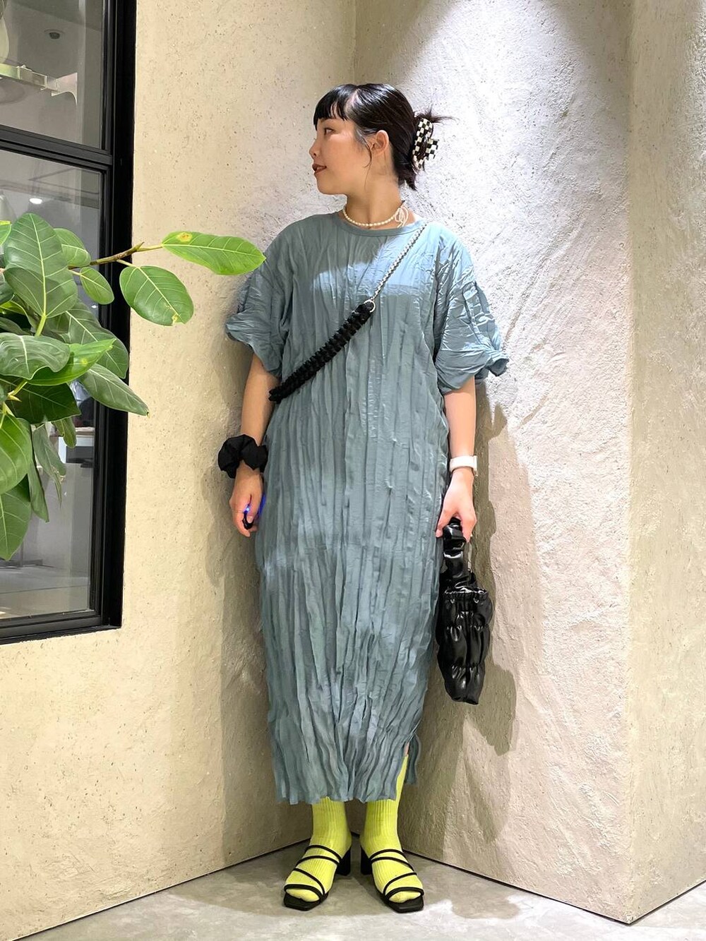 ブラック系のサンダル、ブラック系のショルダーバッグ、ブルー系のワンピースを着用したレディースの夏コーディネートの2枚目の写真