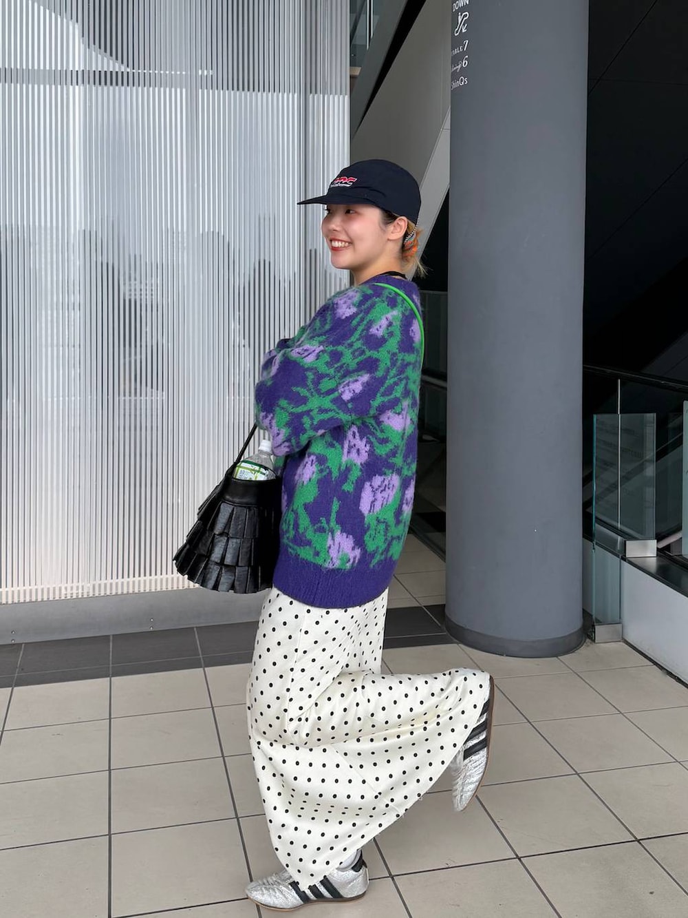 ホワイト系のスカート、ブラック系のハンドバッグ、ブラック系のネックレスを着用したレディースの冬コーディネートの4枚目の写真