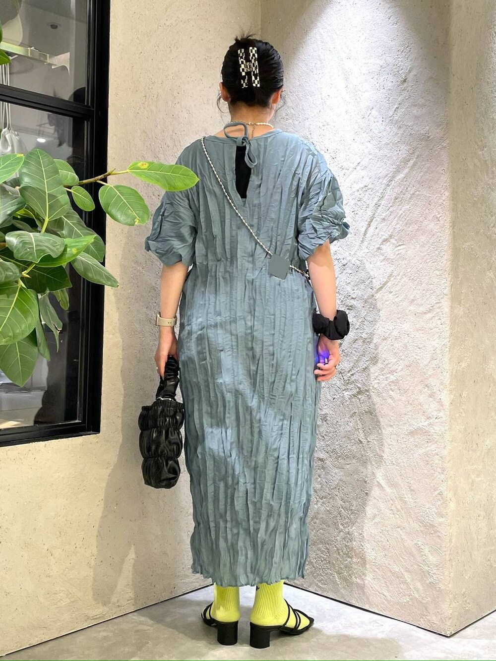 ブラック系のサンダル、ブラック系のショルダーバッグ、ブルー系のワンピースを着用したレディースの夏コーディネートの5枚目の写真