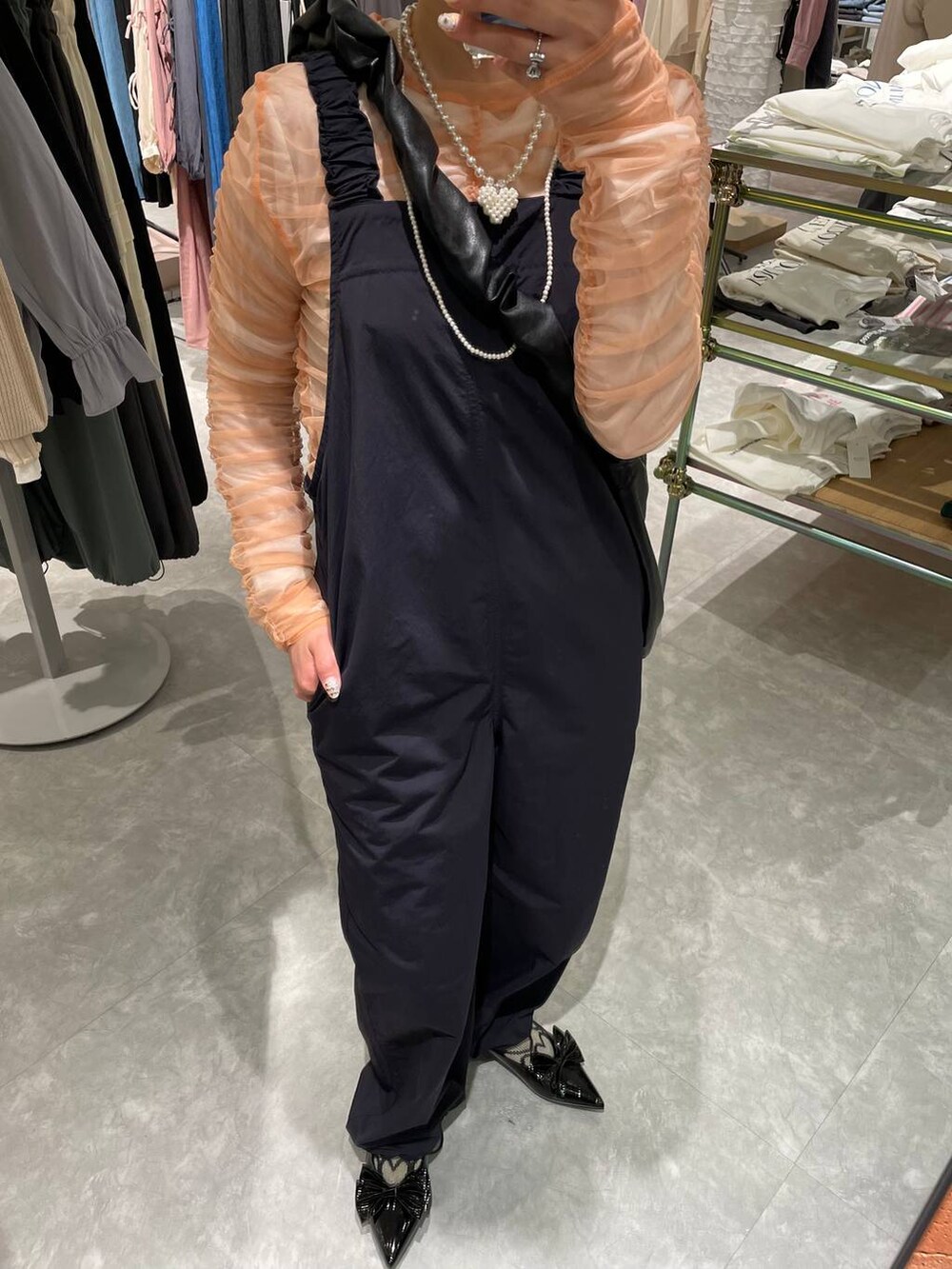 ブラック系のトートバッグ、ブラック系のパンプス、ピンク系のシャツ/ブラウスを着用したレディースの春コーディネートの2枚目の写真