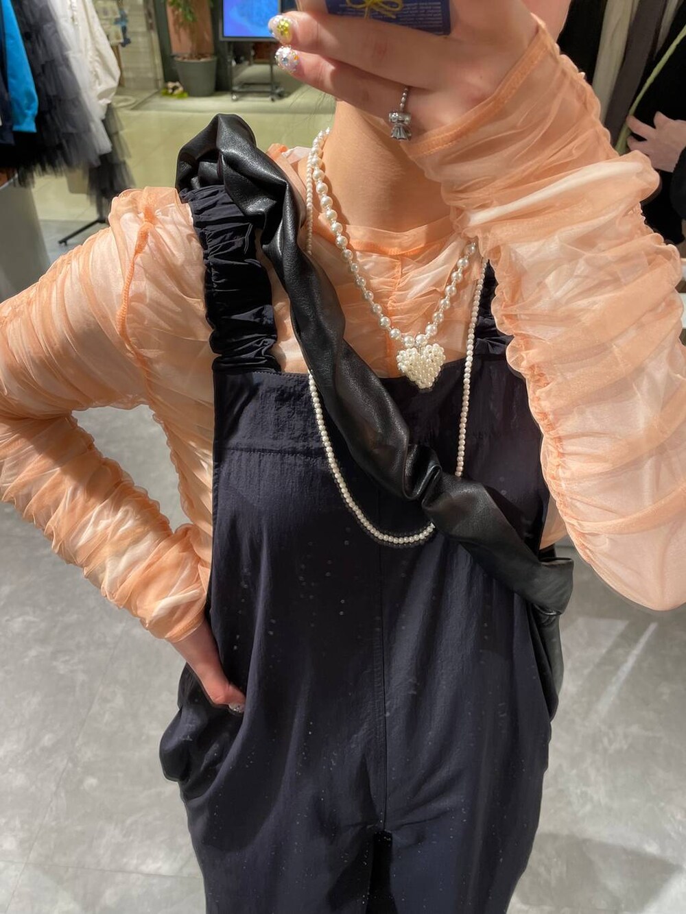 ブラック系のトートバッグ、ブラック系のパンプス、ピンク系のシャツ/ブラウスを着用したレディースの春コーディネートの7枚目の写真