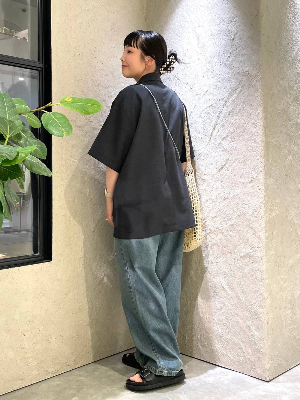 ベージュ系のショルダーバッグ、ブラック系のTシャツ/カットソー、ブルー系のデニムパンツを着用したレディースの夏コーディネートの3枚目の写真