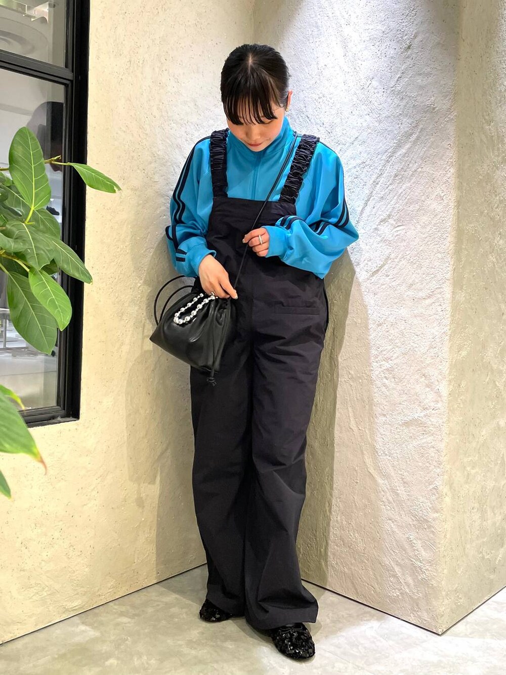 ブラック系のショルダーバッグ、ブルー系のサロペット/オーバーオール、ブルー系のTシャツ/カットソーを着用したレディースの春コーディネートの4枚目の写真