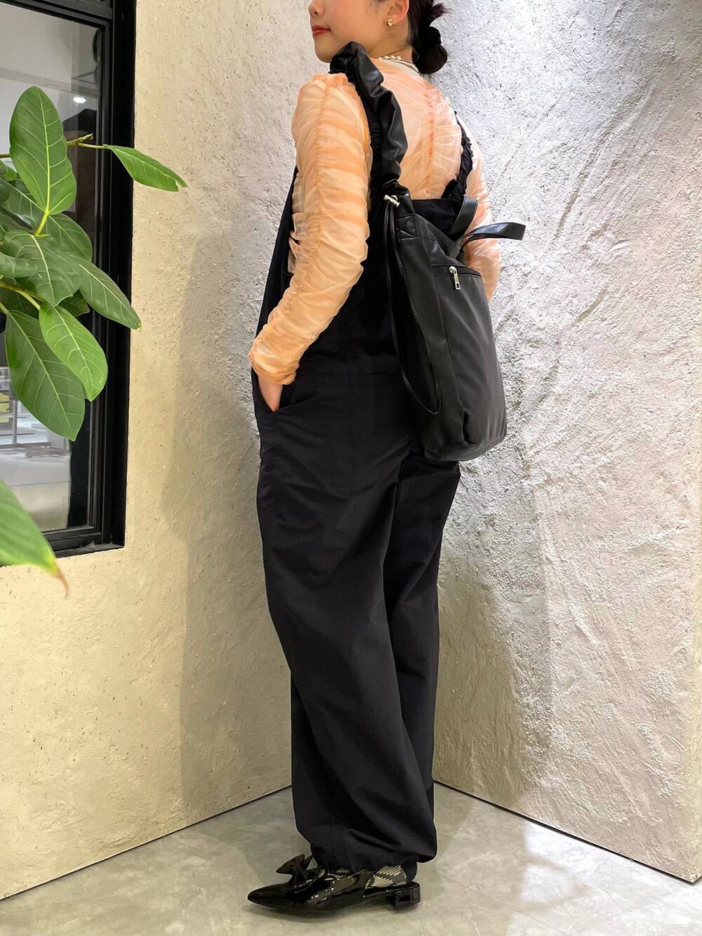 ブラック系のトートバッグ、ブラック系のパンプス、ピンク系のシャツ/ブラウスを着用したレディースの春コーディネートの4枚目の写真