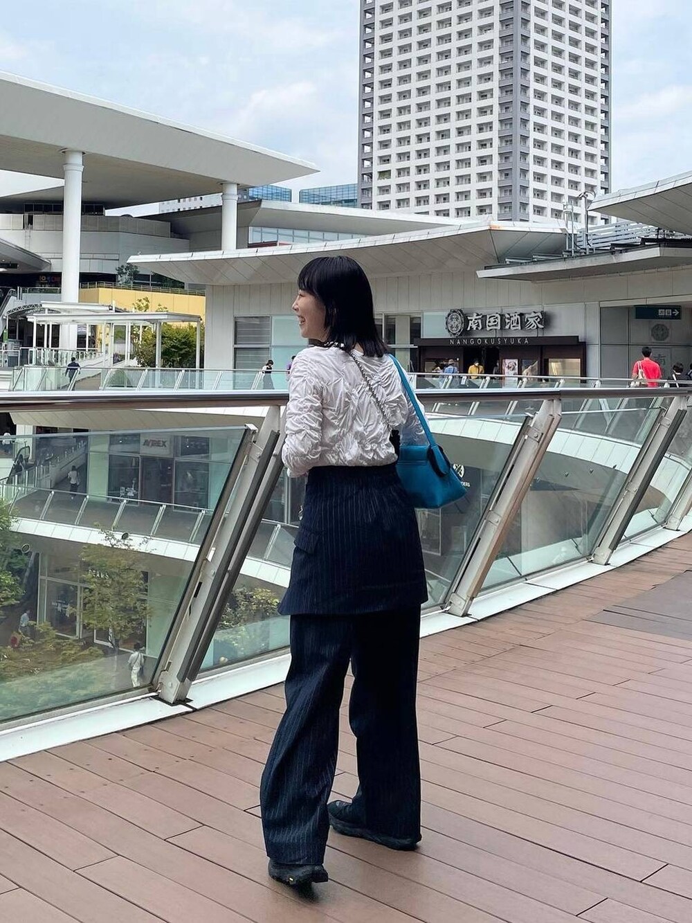 ブルー系のスラックス、その他のイヤリング、シルバー系のリングを着用したレディースの秋コーディネートの5枚目の写真