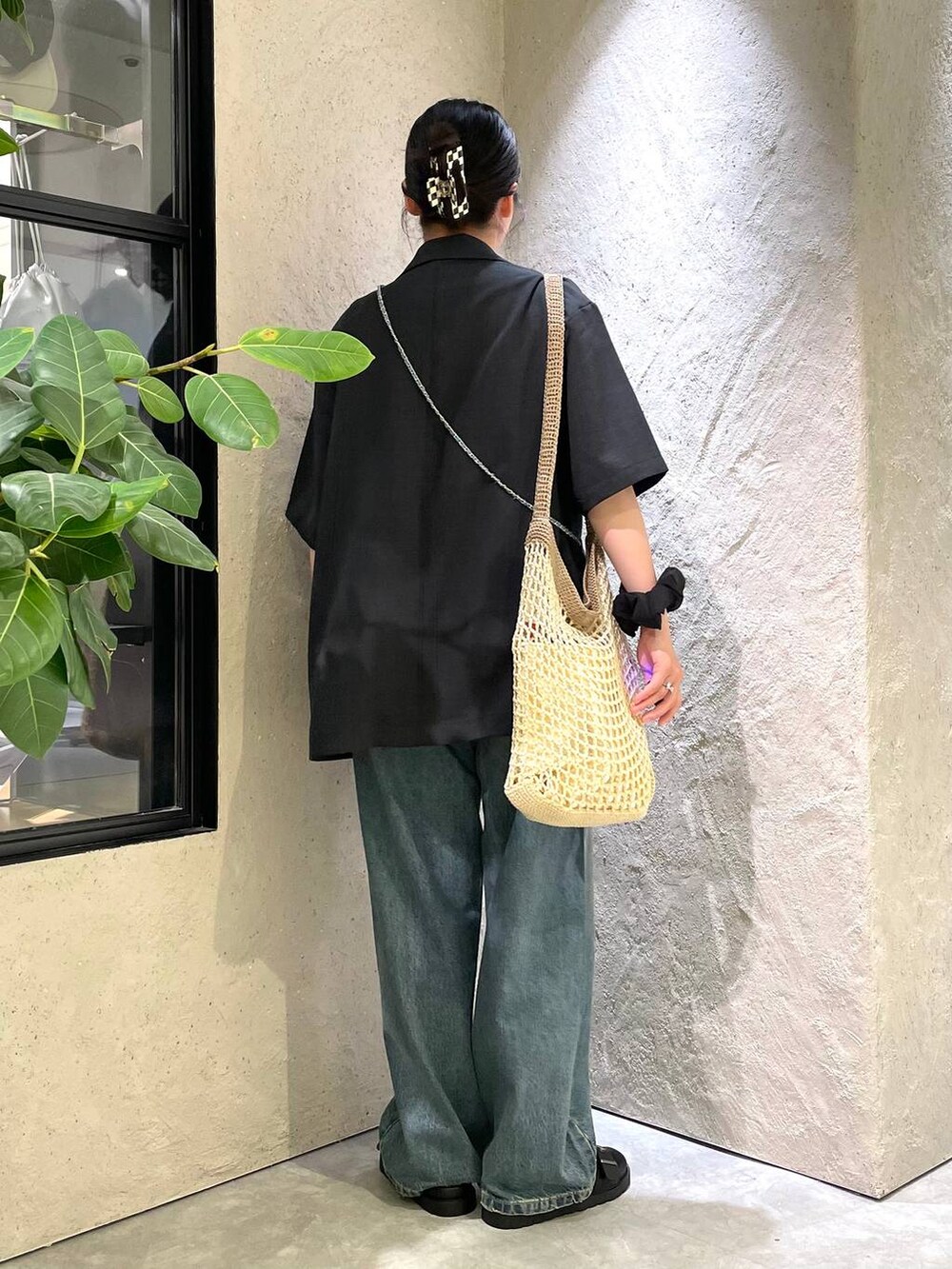 ベージュ系のショルダーバッグ、ブラック系のTシャツ/カットソー、ブルー系のデニムパンツを着用したレディースの夏コーディネートの4枚目の写真