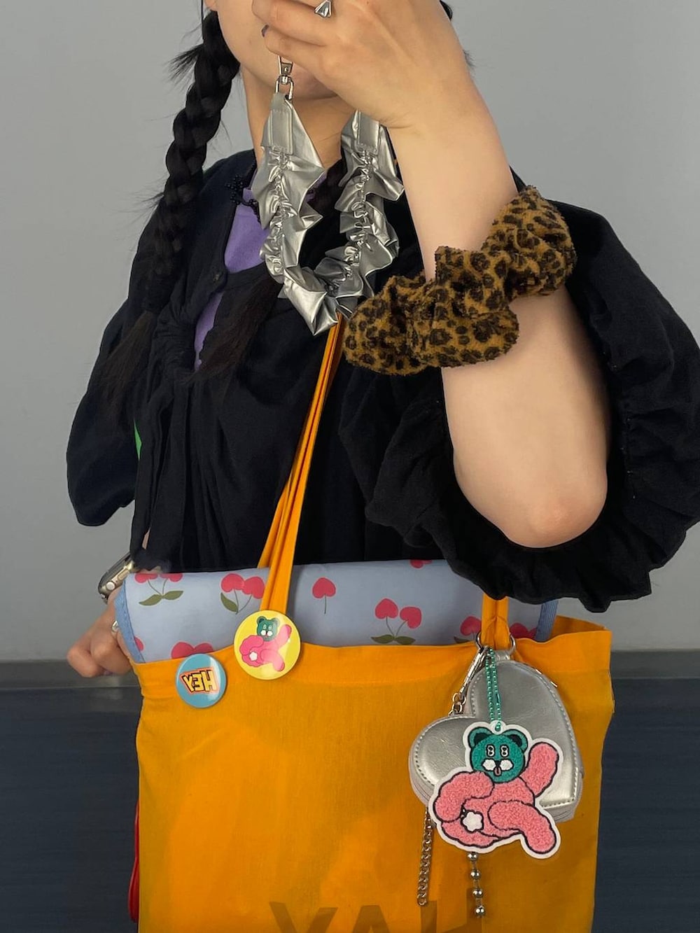 ブルー系のキャップ、シルバー系のスマホグッズ、ブラウン系のシュシュを着用したレディースの春コーディネートの3枚目の写真