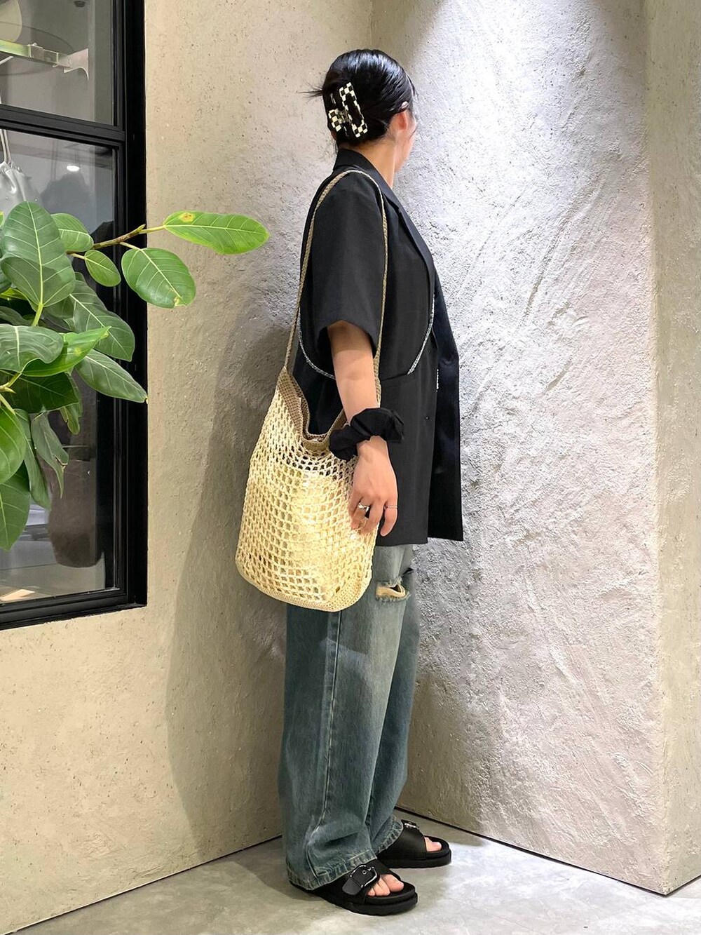 ベージュ系のショルダーバッグ、ブラック系のTシャツ/カットソー、ブルー系のデニムパンツを着用したレディースの夏コーディネートの5枚目の写真