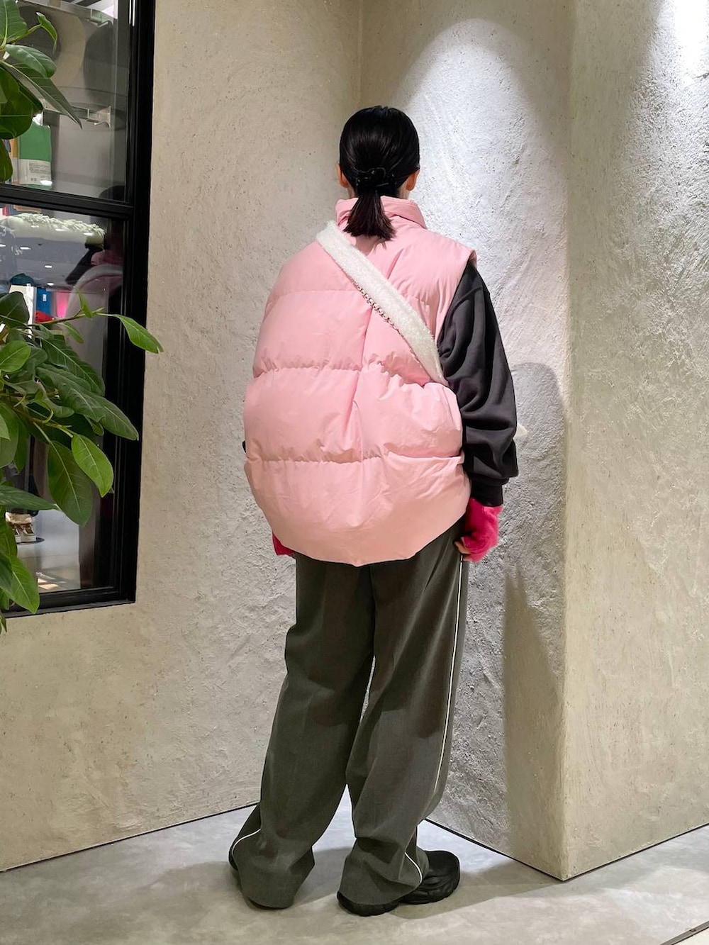 ピンク系のダウンベスト、グレー系のその他パンツ、ブラック系のスウェットを着用したレディースの秋コーディネートの3枚目の写真