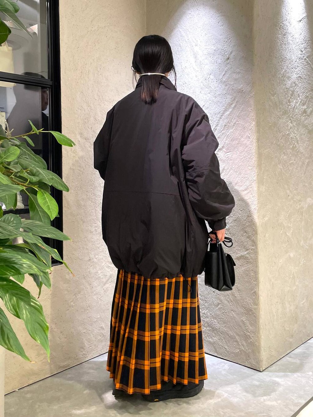 ブラック系のショルダーバッグ、ブラック系のダウンジャケット/コート、ブラック系のTシャツ/カットソーを着用したレディースの冬コーディネートの3枚目の写真