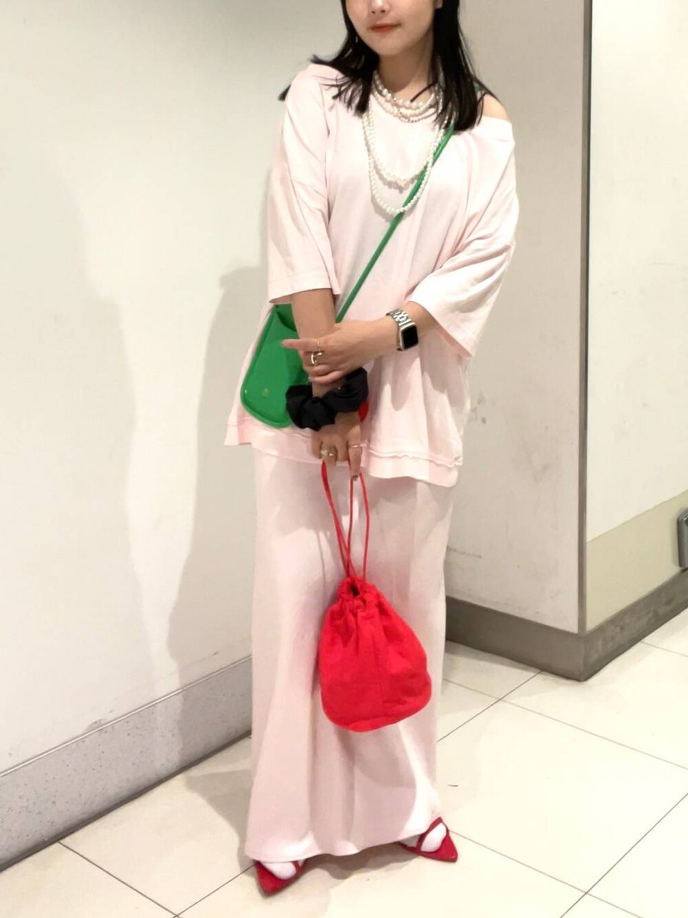 レッド系のサンダル、ブラック系のキャミソール、ピンク系のスカートを着用したレディースの夏コーディネートの2枚目の写真