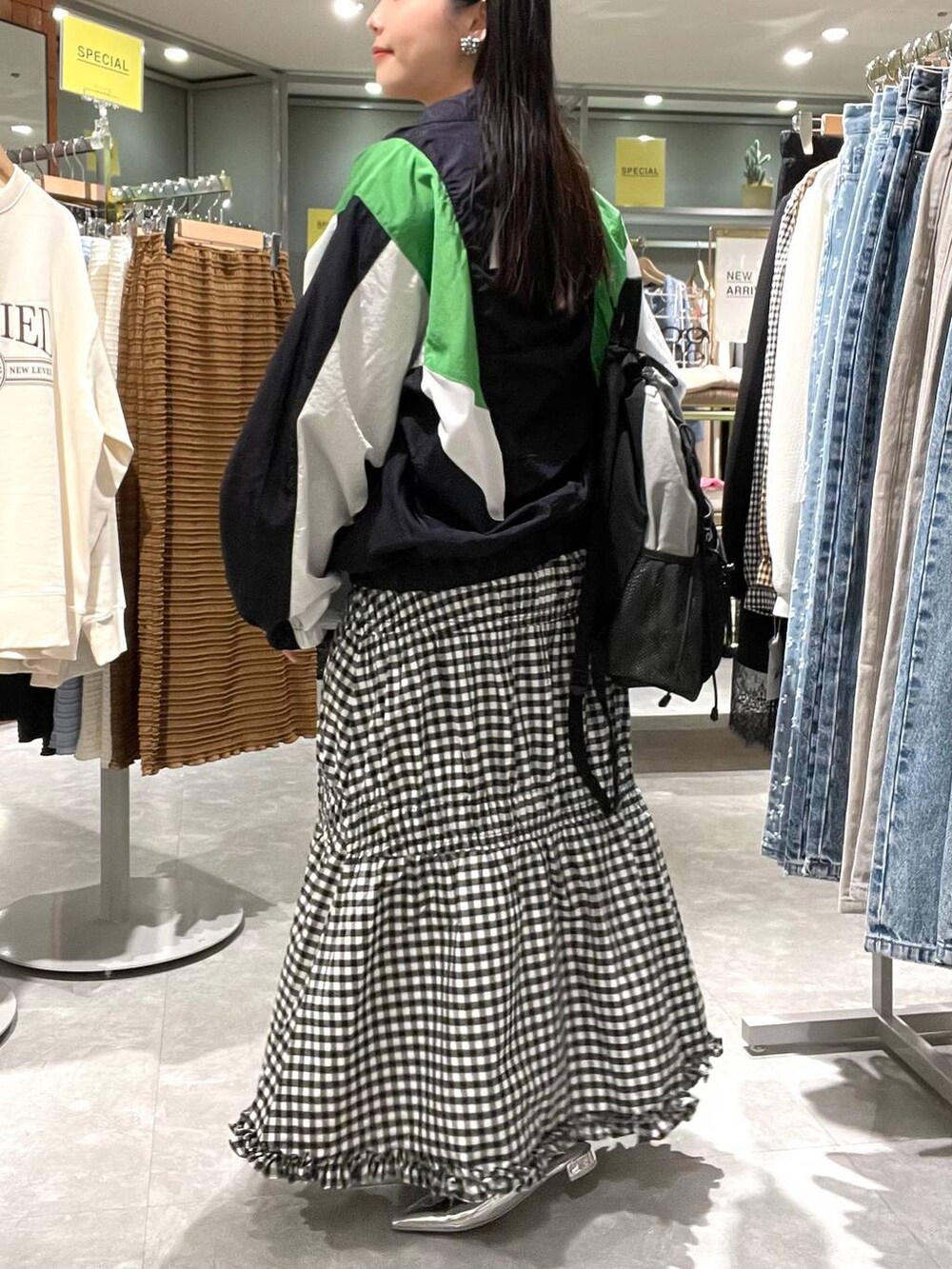 シルバー系のパンプス、ブルー系のブルゾン、ブラック系のバックパック/リュックを着用したレディースの春コーディネートの3枚目の写真