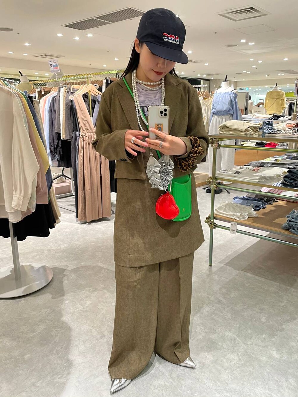 ブラウン系のスラックス、ブラウン系のテーラードジャケット、ブラウン系のキャミソールを着用したレディースの春コーディネートの8枚目の写真