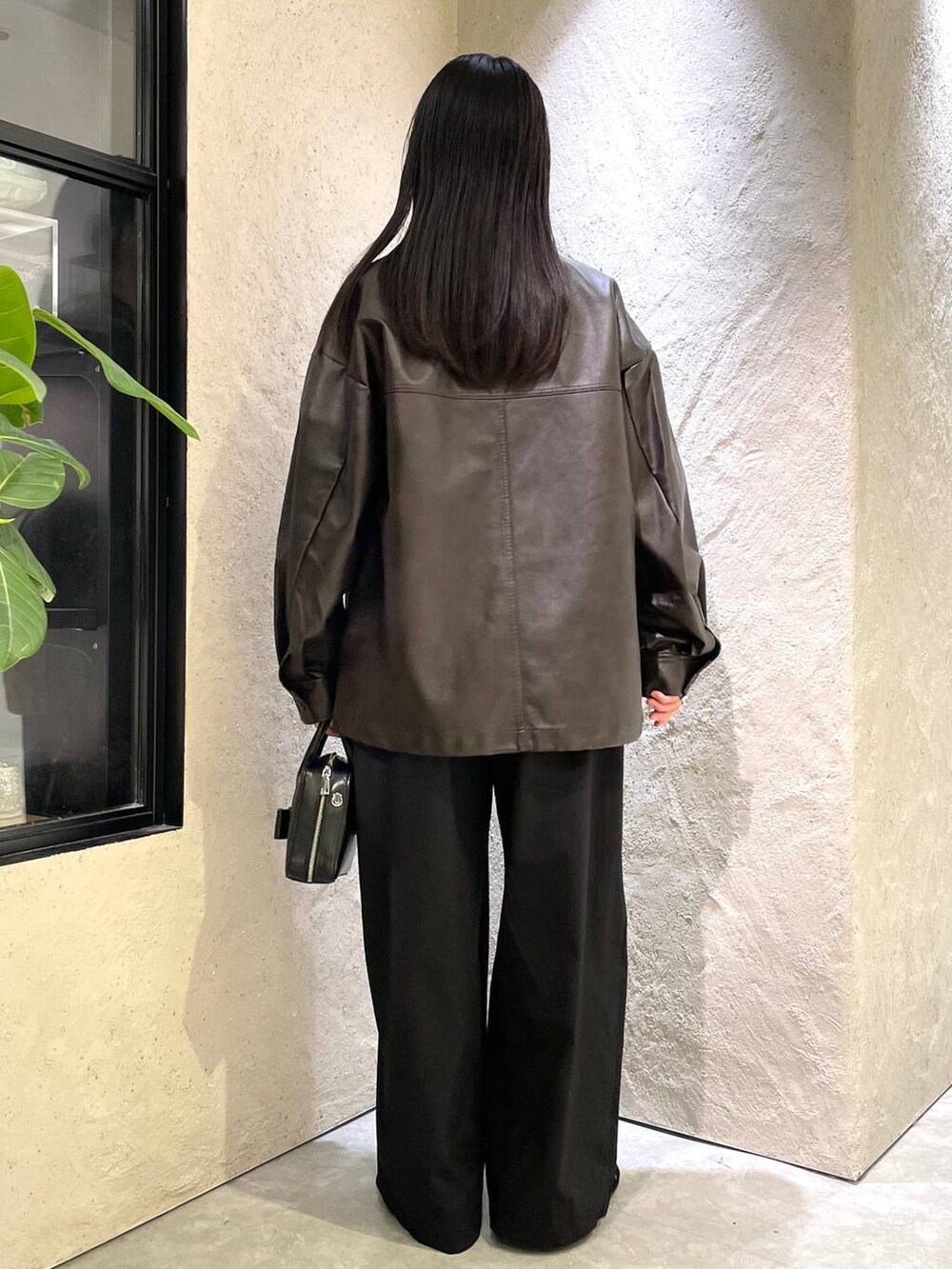 ブラウン系のブルゾン、ブラック系のバレエシューズ、ブラック系のボストンバッグを着用したレディースの秋コーディネートの5枚目の写真