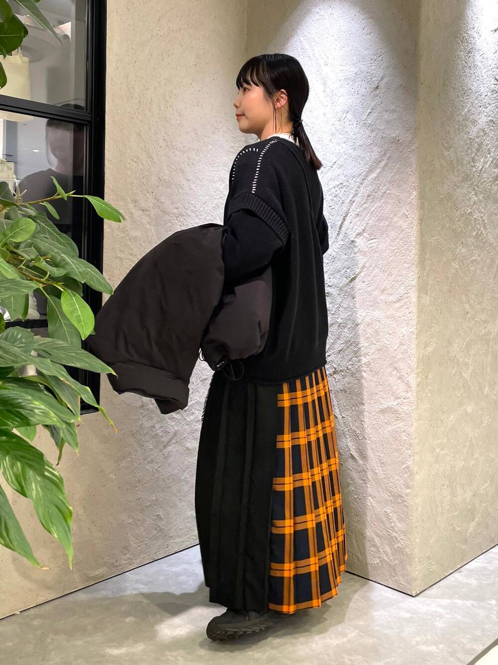 ブラック系のショルダーバッグ、ブラック系のダウンジャケット/コート、ブラック系のTシャツ/カットソーを着用したレディースの冬コーディネートの7枚目の写真