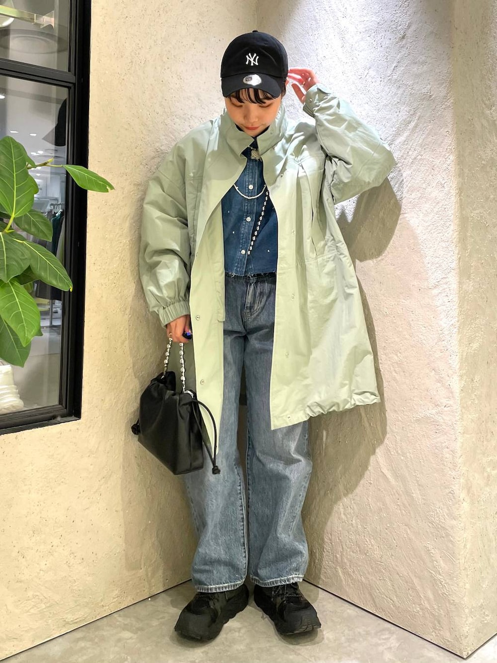 ブラック系のショルダーバッグ、ブルー系のデニムパンツ、ブルー系のシャツ/ブラウスを着用したレディースの春コーディネートの2枚目の写真