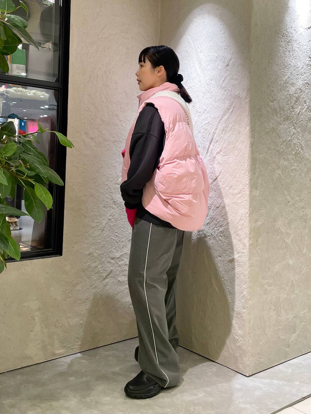 ピンク系のダウンベスト、グレー系のその他パンツ、ブラック系のスウェットを着用したレディースの秋コーディネートの2枚目の写真