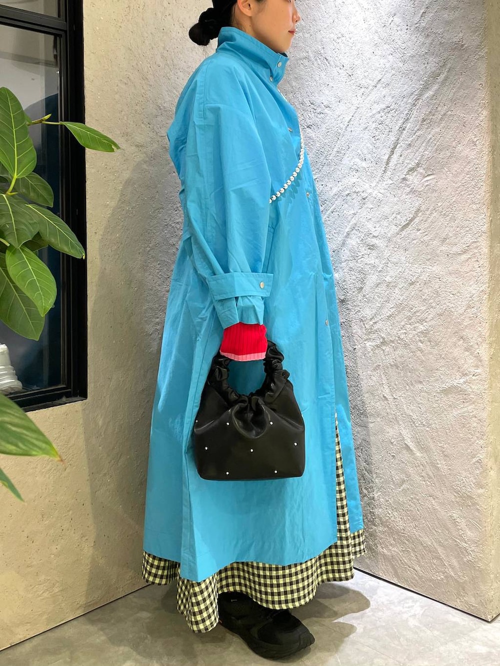 ブラック系のハンドバッグ、グリーン系のワンピース、ブルー系のブルゾンを着用したレディースの春コーディネートの4枚目の写真