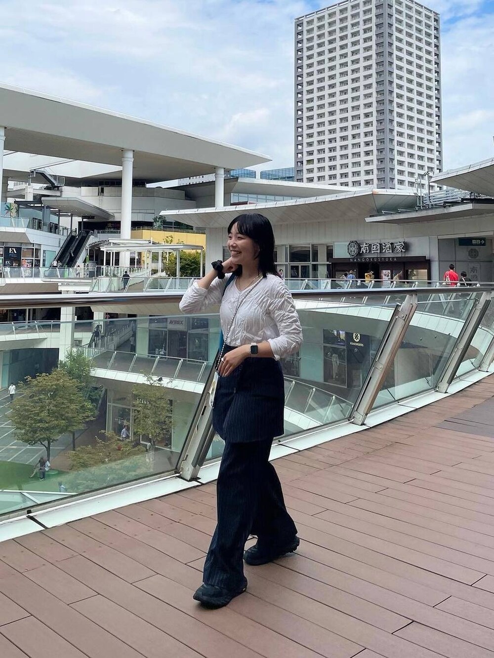 ブルー系のスラックス、その他のイヤリング、シルバー系のリングを着用したレディースの秋コーディネートの4枚目の写真