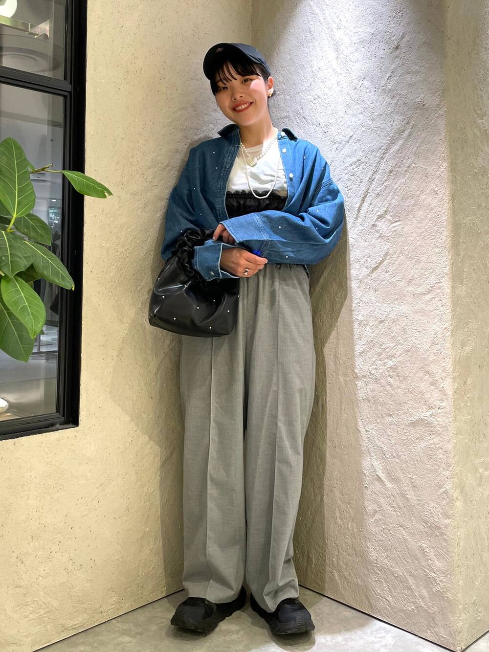 ブラック系のハンドバッグ、ブラック系のTシャツ/カットソー、ブルー系のシャツ/ブラウスを着用したレディースの春コーディネートの6枚目の写真