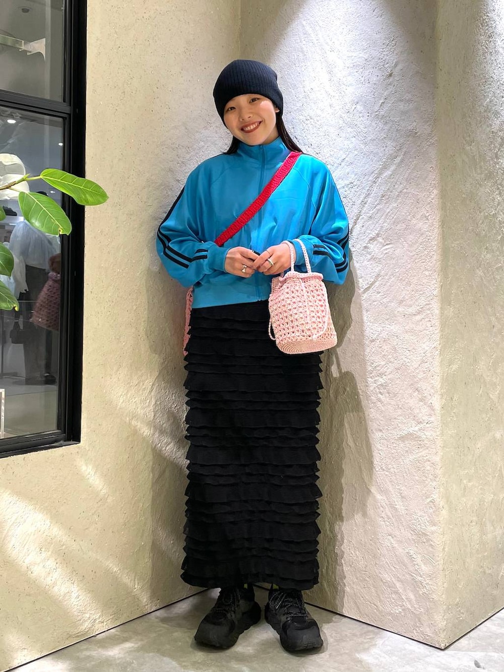 ピンク系のショルダーバッグ、ブルー系のTシャツ/カットソー、ブラック系のスカートを着用したレディースの春コーディネートの2枚目の写真