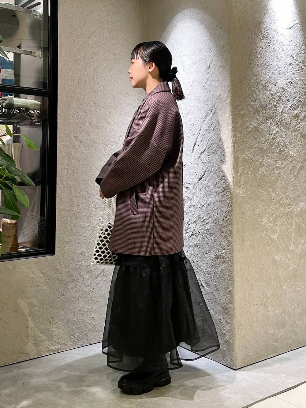 ブラック系のブーツ、ホワイト系のショルダーバッグ、ブラック系のニット/セーターを着用したレディースの秋コーディネートの2枚目の写真