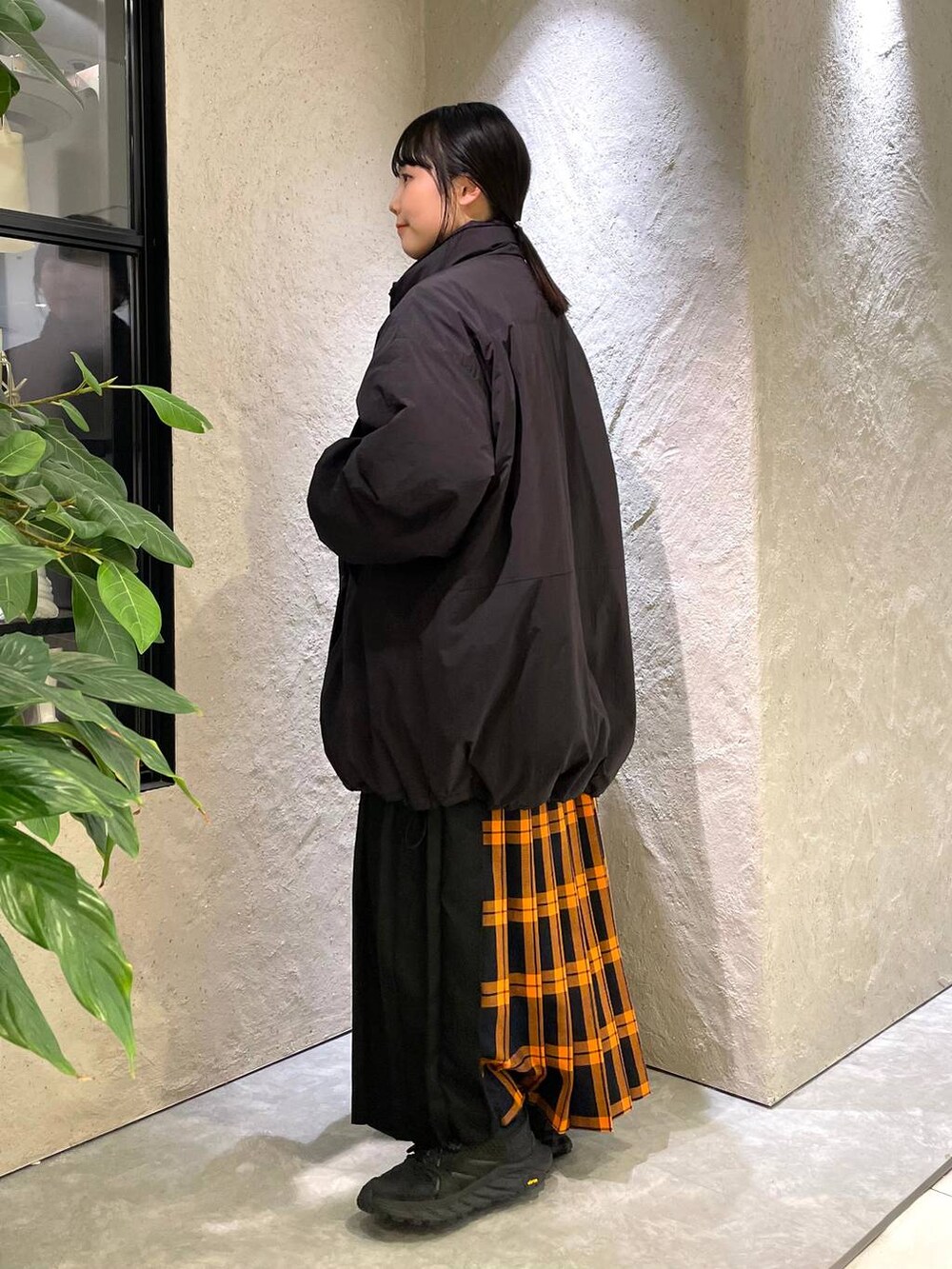 ブラック系のショルダーバッグ、ブラック系のダウンジャケット/コート、ブラック系のTシャツ/カットソーを着用したレディースの冬コーディネートの2枚目の写真