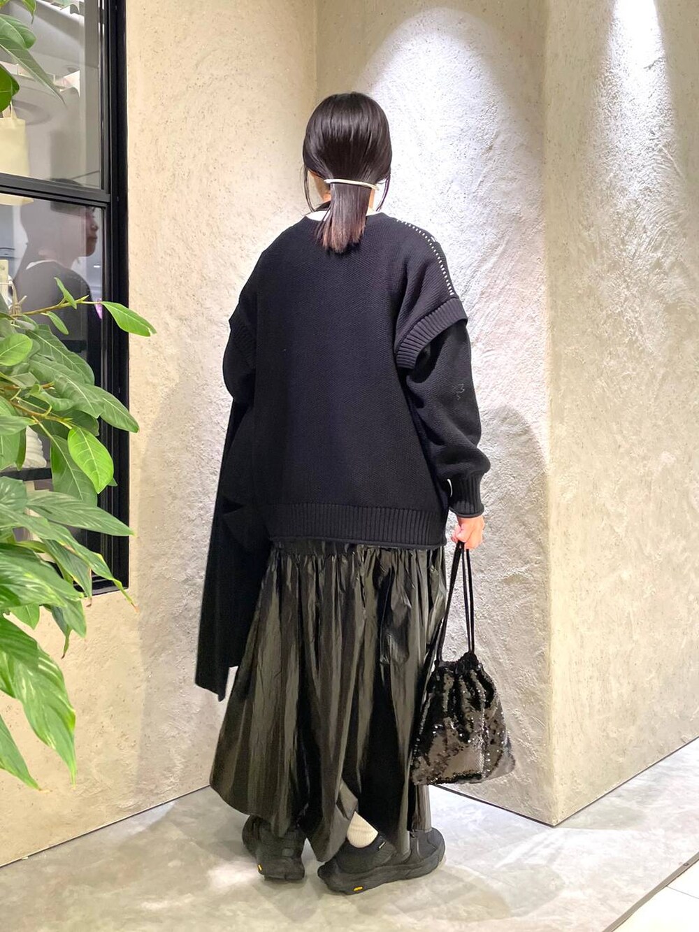 ブラック系のトレンチコート、ブラック系のTシャツ/カットソー、ブラック系のハンドバッグを着用したレディースの冬コーディネートの3枚目の写真