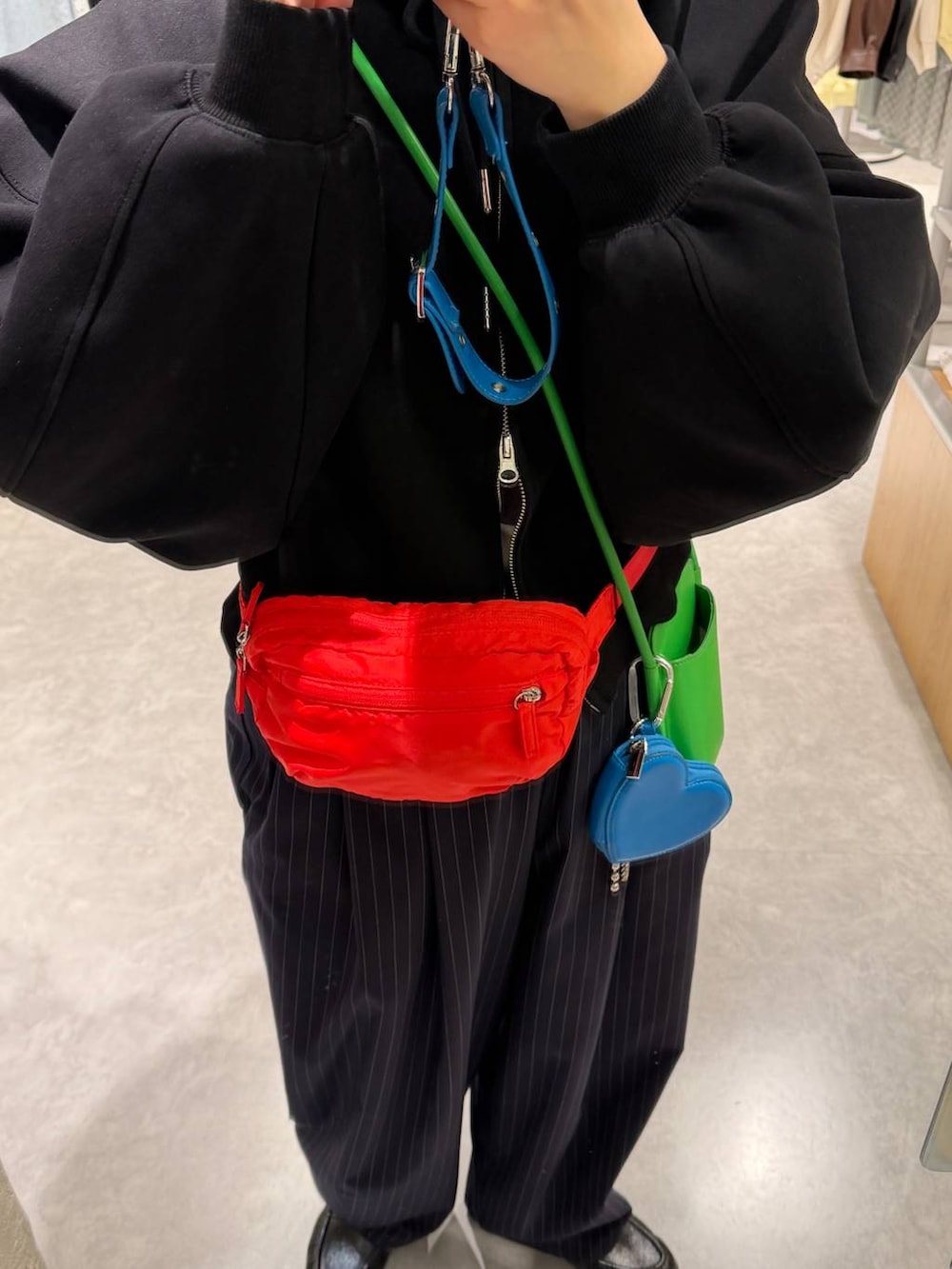 ブルー系のその他パンツ、ブラック系のパーカー、レッド系のボディバッグ/ウエストポーチを着用したレディースの冬コーディネートの2枚目の写真