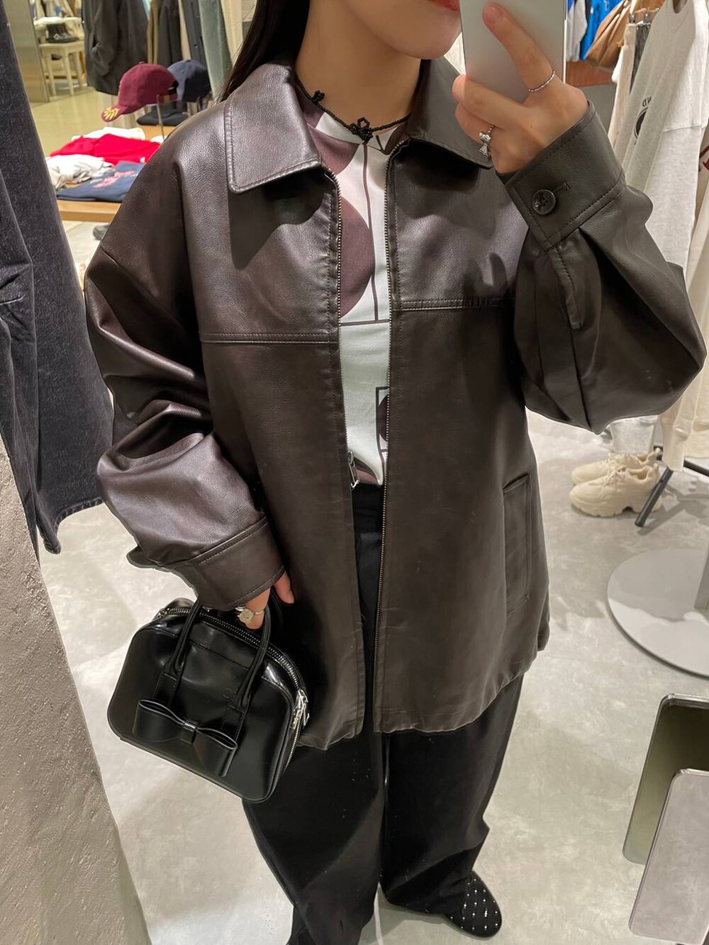 ブラウン系のブルゾン、ブラック系のバレエシューズ、ブラック系のボストンバッグを着用したレディースの秋コーディネートの7枚目の写真