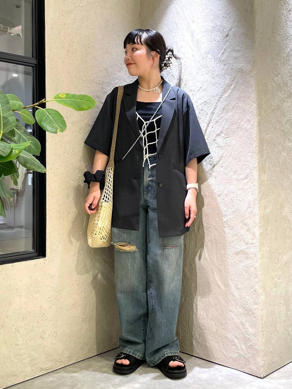 ベージュ系のショルダーバッグ、ブラック系のTシャツ/カットソー、ブルー系のデニムパンツを着用したレディースの夏コーディネートの2枚目の写真