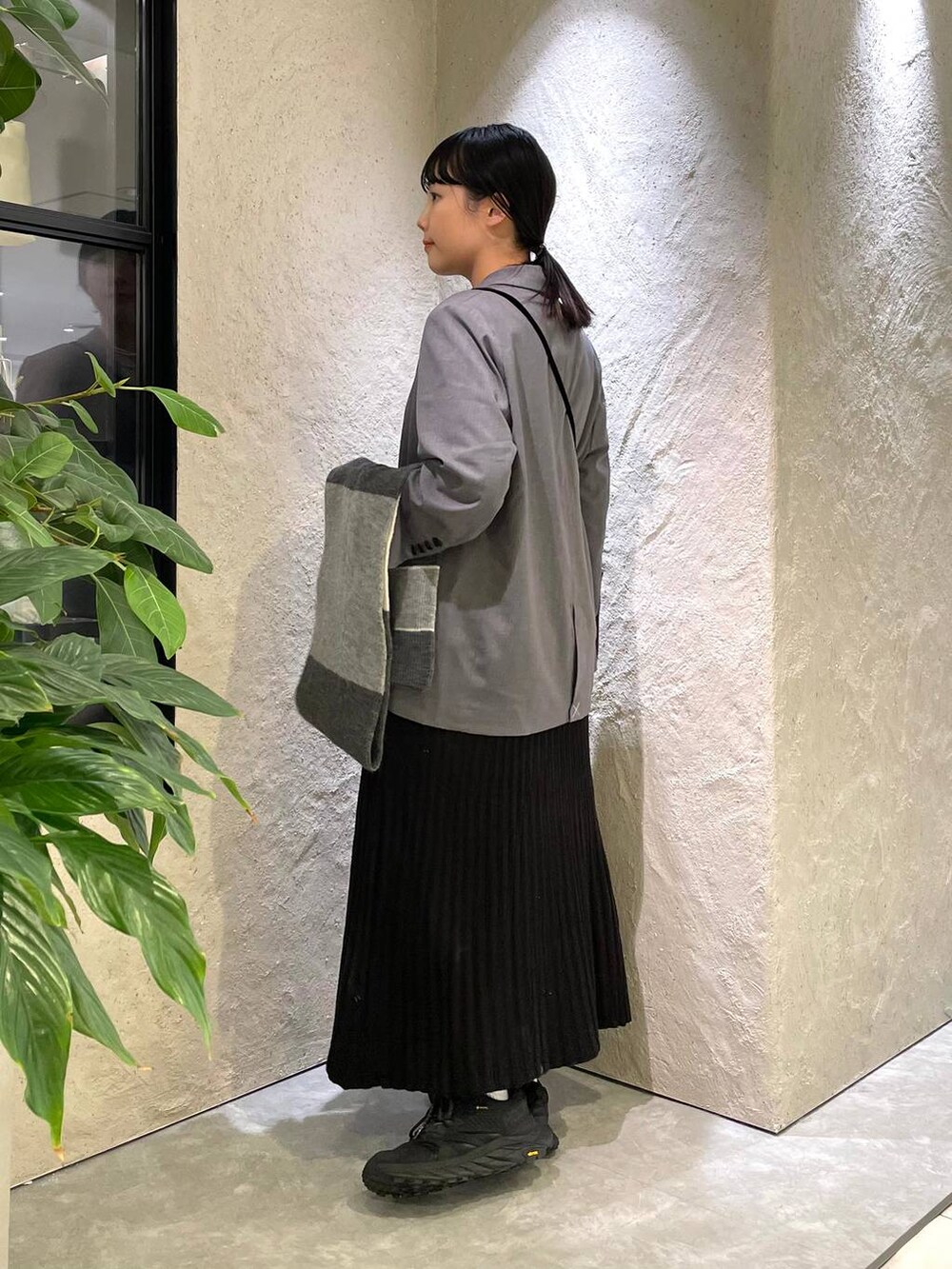 ブラック系のハンドバッグ、ブラック系のワンピース、ホワイト系のTシャツ/カットソーを着用したレディースの冬コーディネートの2枚目の写真