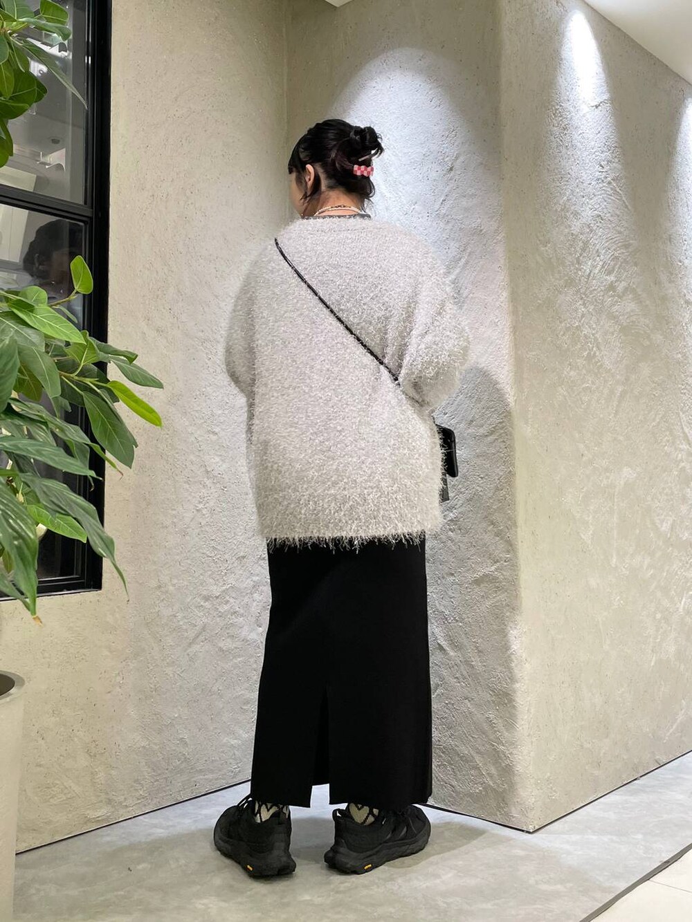 ブラック系のショルダーバッグ、グレー系のカーディガン/ボレロ、グレー系のTシャツ/カットソーを着用したレディースの秋コーディネートの4枚目の写真