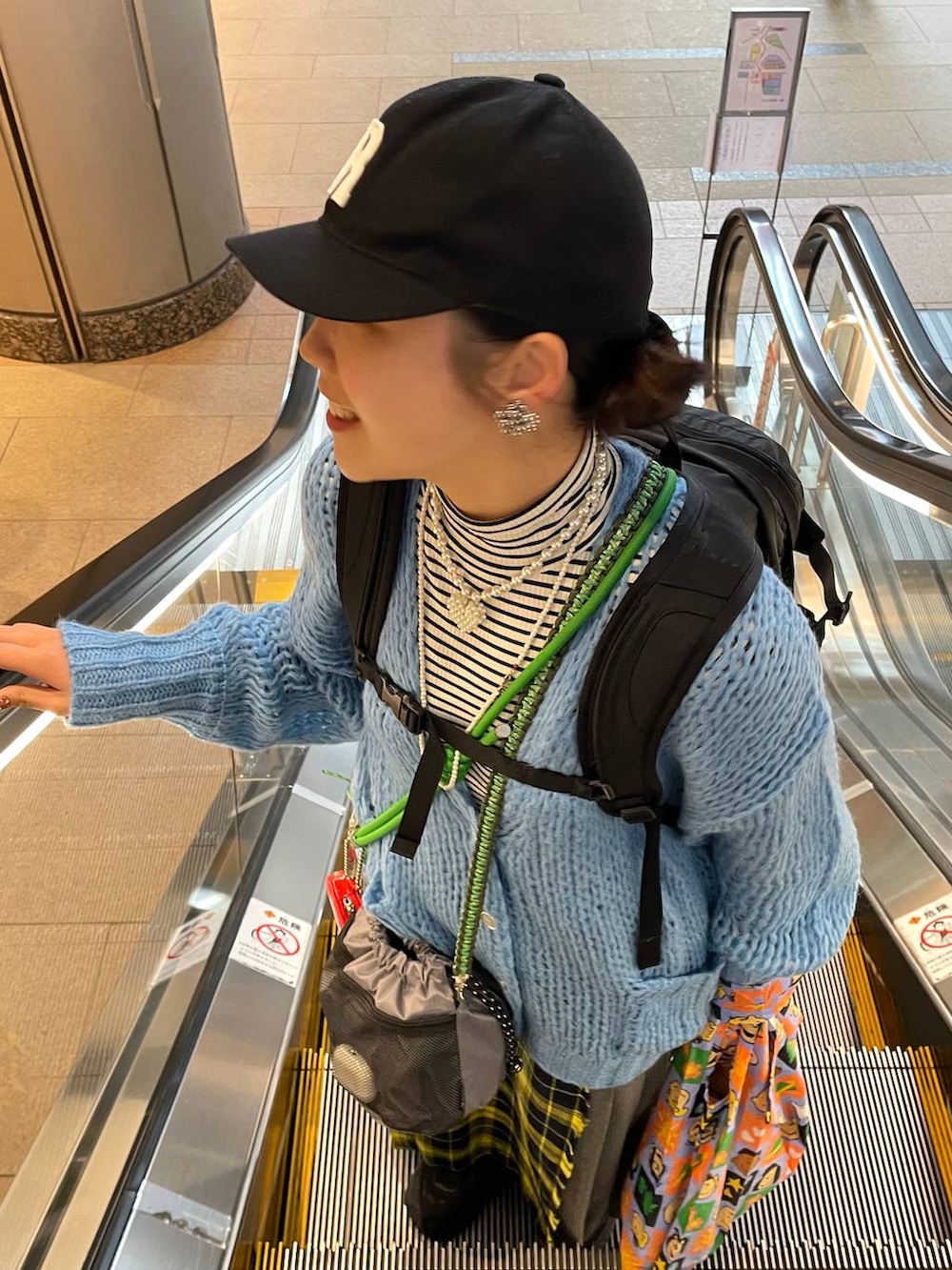 ホワイト系のTシャツ/カットソー、イエロー系のスカート、ブルー系のカーディガン/ボレロを着用したレディースの春コーディネートの3枚目の写真