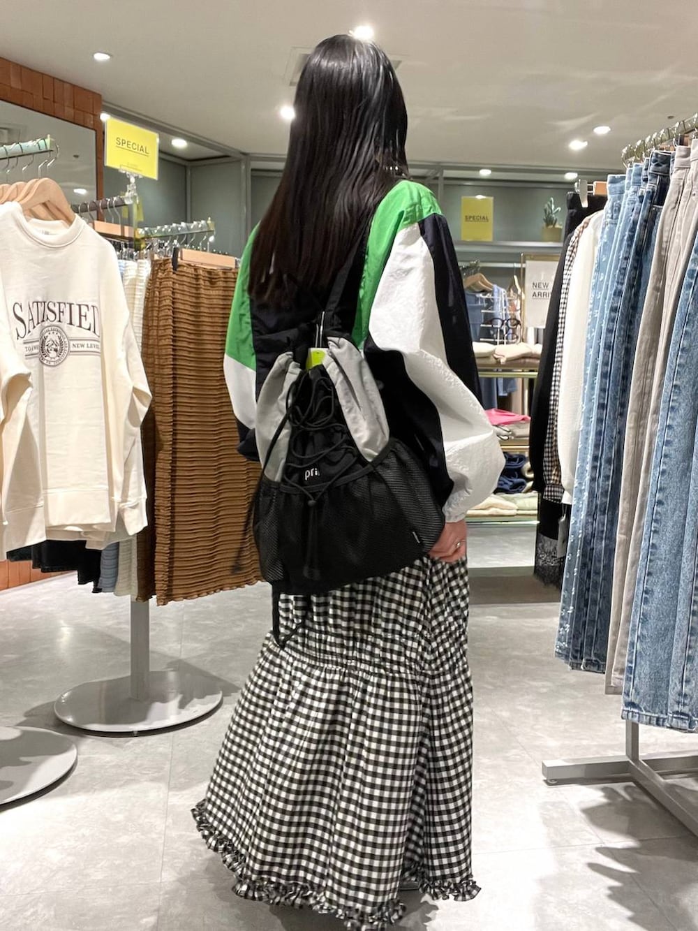 シルバー系のパンプス、ブルー系のブルゾン、ブラック系のバックパック/リュックを着用したレディースの春コーディネートの4枚目の写真