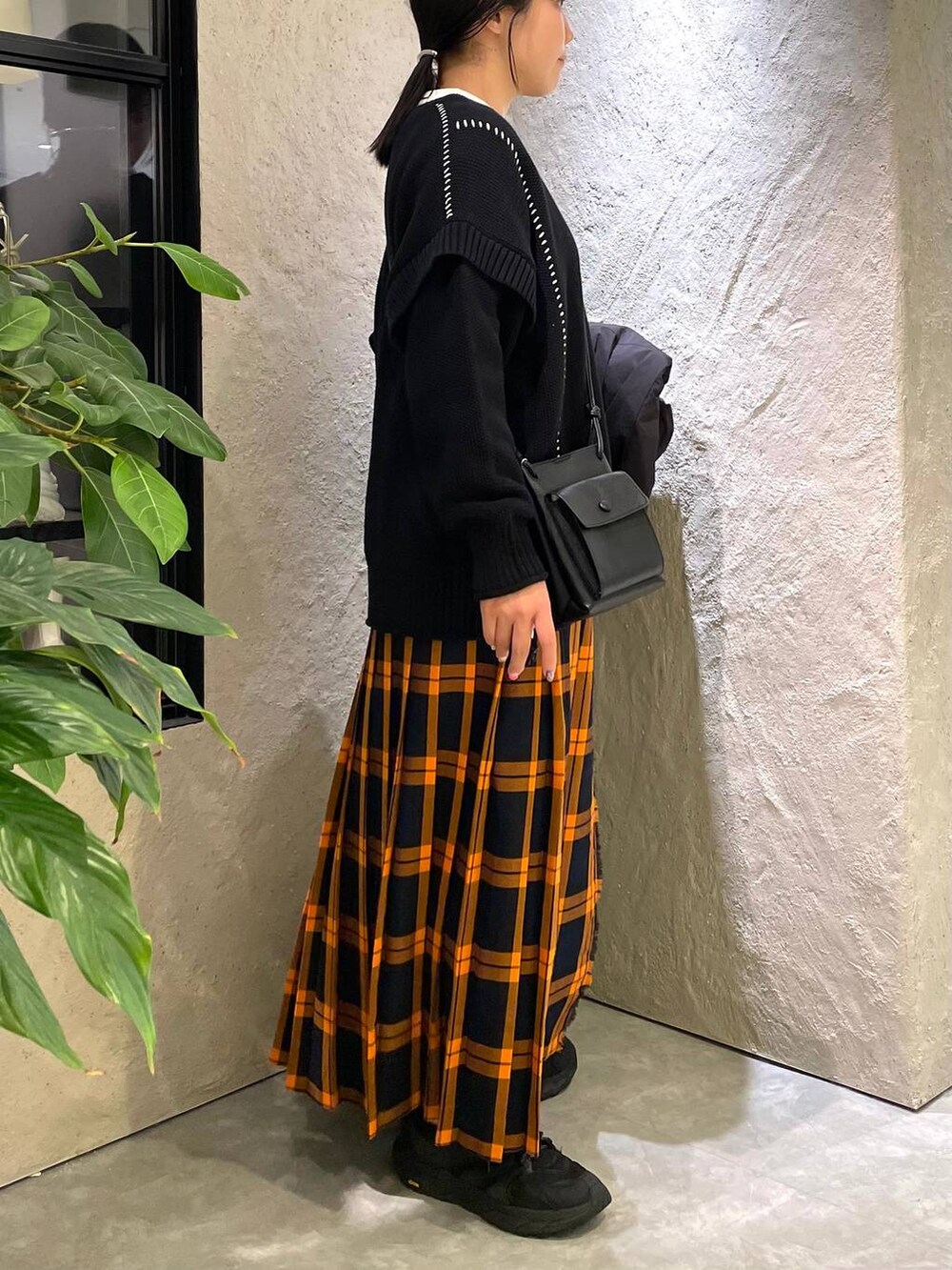 ブラック系のショルダーバッグ、ブラック系のダウンジャケット/コート、ブラック系のTシャツ/カットソーを着用したレディースの冬コーディネートの9枚目の写真