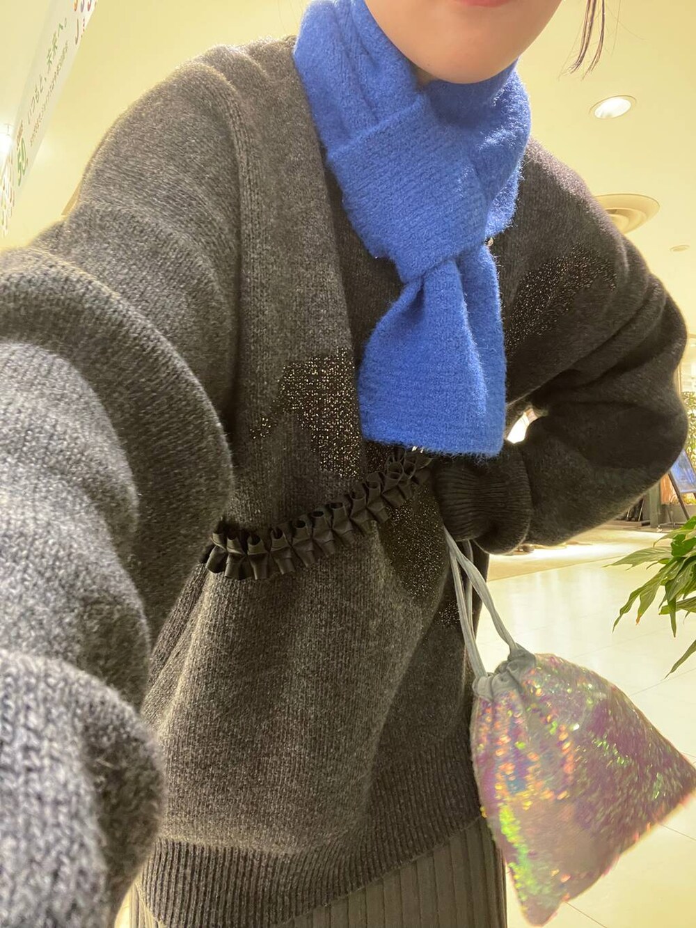 ホワイト系のハンドバッグ、グレー系のワンピース、ブラック系のブーツを着用したレディースの冬コーディネートの5枚目の写真