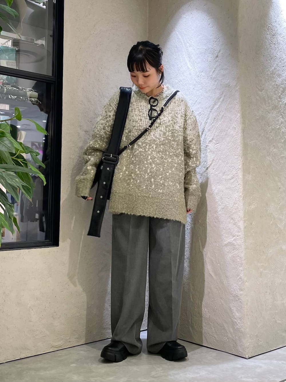 ブラック系のブーツ、グレー系のその他パンツ、グリーン系のニット/セーターを着用したレディースの秋コーディネートの2枚目の写真