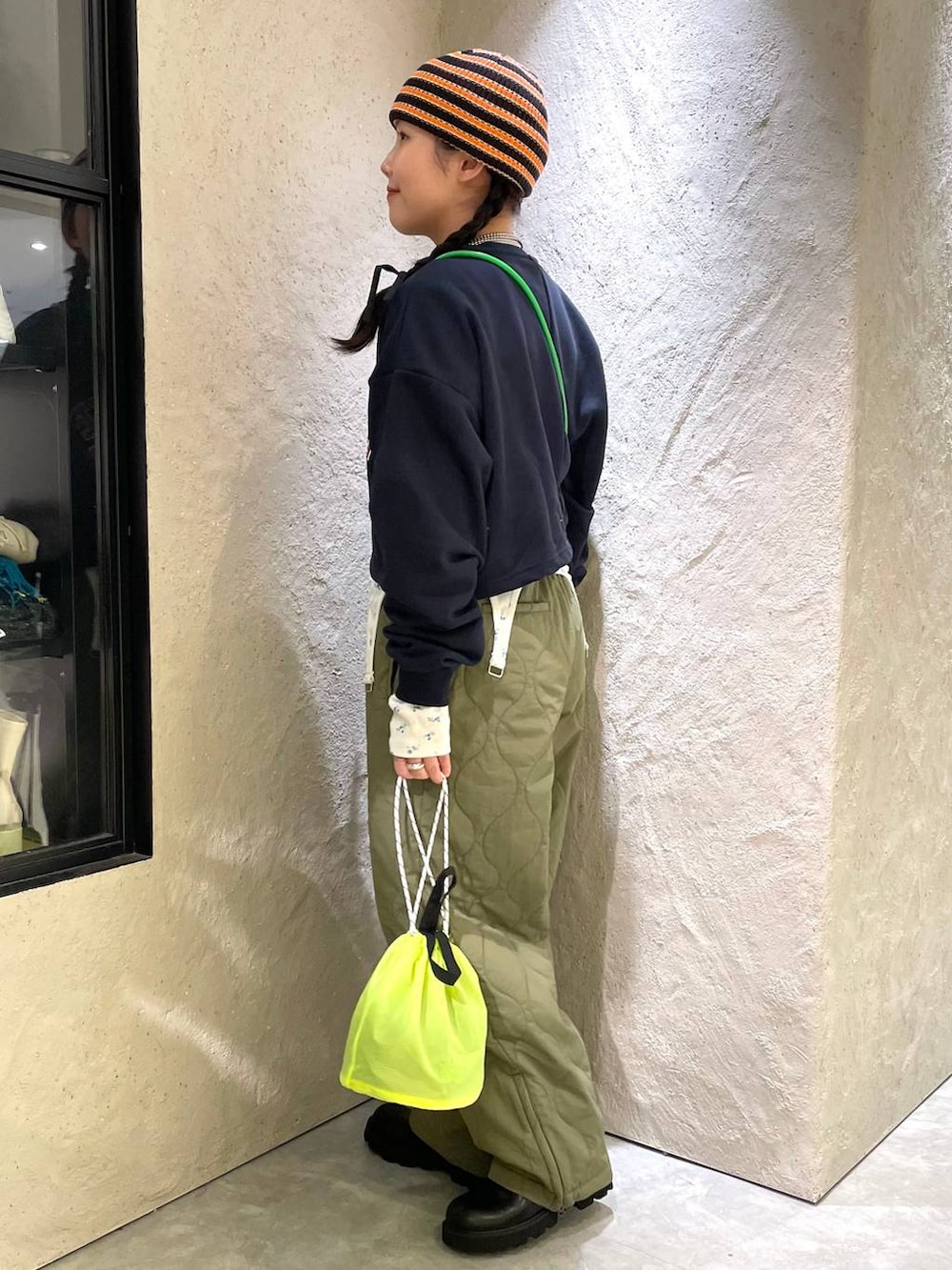 グリーン系のその他パンツ、ブラック系のブーツ、イエロー系のショルダーバッグを着用したレディースの冬コーディネートの3枚目の写真