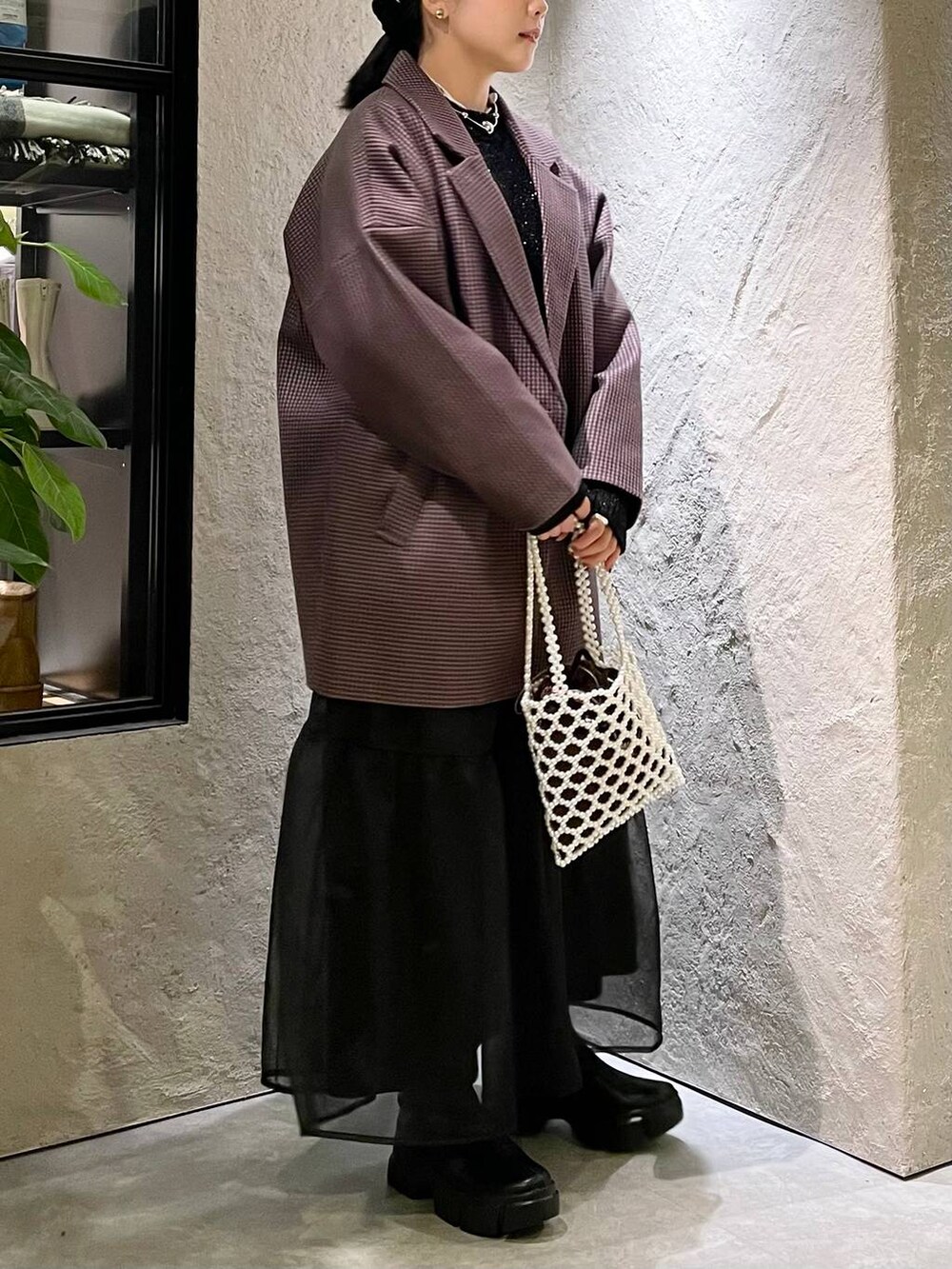 ブラック系のブーツ、ホワイト系のショルダーバッグ、ブラック系のニット/セーターを着用したレディースの秋コーディネートの4枚目の写真